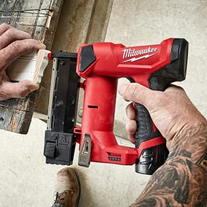 Man uses Milwaukee 23 Gauge Pin Nailer for accurate pin placement on delicate trim pieces.