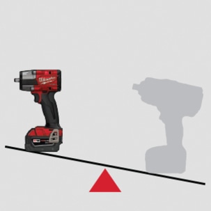 Milwaukee mid-torque impact wrench on scale against high torque wrench to demonstrate its lighter weight.