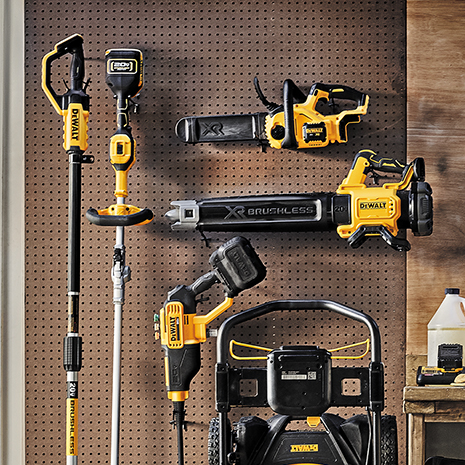 Array of outdoor power tools hanging on garage wall