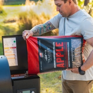 Traeger Apple pellets being poured into the grill hopper. Traeger Apple pellets being poured into the grill hopper.