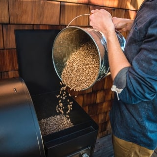 Traeger Pellets being poured into the hopper of a Traeger Grill. Traeger Pellets being poured into the hopper of a Traeger Grill.