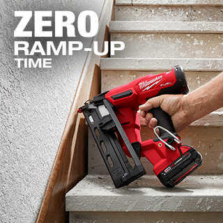 Man uses Milwaukee M18 FUEL finish nailer to attach stair baseboard.