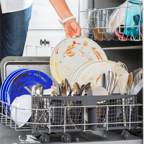 Woman loading dirty dishes into the dishwasher