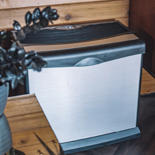 AIRCARE silver Valiant evaporative humidifier against a wood background