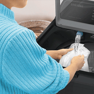 Image of someone cleaning clothing with water from the Active WaterJet feature.