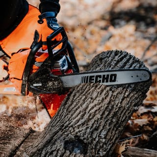 Chainsaw cutting large tree trunk