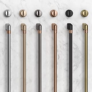 6 sets of hardware, each with a knob and a handle in the available finishes, rest on a white marble surface.