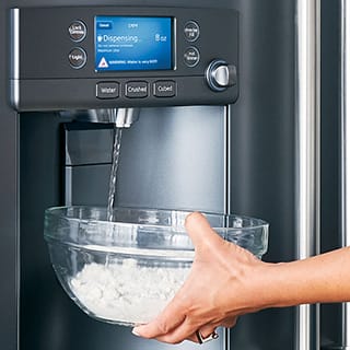 A woman accurately fills a glass bowl full of flour with water through the dispenser.