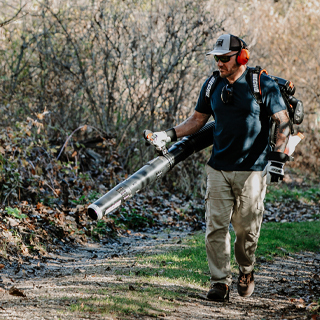 Man blowing leaves away with ECHO backpack blower