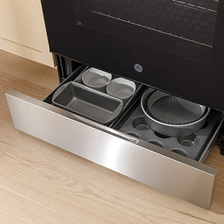 An image of the oven door open to reveal a whole turkey and two side dishes being prepared simultaneously.