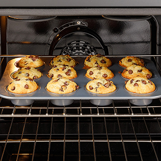 An inside-the-oven view of chocolate chip muffins that are perfectly baked.